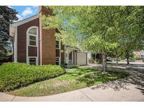 Charming home featuring a brick chimney, lush landscaping, and a well-maintained lawn at 16724 E Hialeah Ave, Centennial, CO 80015