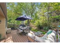 Beautiful outdoor deck with seating, table, umbrella, and lush green surroundings create a perfect relaxation space at 5050 W 102 Ave, Westminster, CO 80031