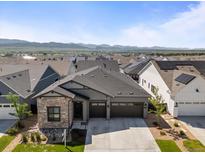 A lovely gray two-story home features a stone accent wall and a two-car garage at 11383 Autumn Moon St, Littleton, CO 80125