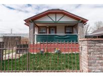 Charming home featuring a well-maintained front yard, secure fencing, and a welcoming porch at 4849 Lincoln St, Denver, CO 80216