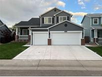 Charming two-story home featuring a two-car garage, well-manicured lawn, and inviting front porch at 9884 Sydney Ln, Highlands Ranch, CO 80130