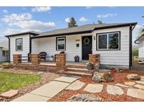Charming home featuring a cozy front porch with stone accents and a well-manicured landscaped front yard at 2120 Oak Pl, Thornton, CO 80229