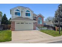 Charming two-story home featuring a brick and siding exterior with attached two car garage at 8229 S Ogden Cir, Littleton, CO 80122