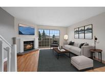 Bright living room with a cozy fireplace and a sliding door to a balcony at 1818 S Quebec Way # 7-8, Denver, CO 80231