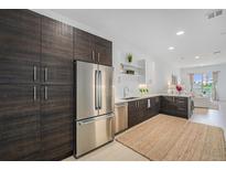 Stylish kitchen boasting stainless steel appliances, wood cabinetry, and an open-concept design at 2530 Lawrence St # Ra301, Denver, CO 80205