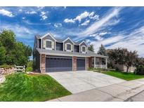 Charming home showcasing a spacious three car garage and well-manicured lawn at 581 Stonemont Dr, Castle Pines, CO 80108