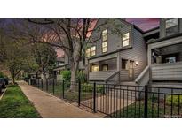 Charming townhouse with gray siding, a cozy porch, and a manicured front yard at 2 Acoma St # 11, Denver, CO 80223