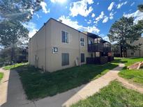 Two-story condo building with wooden balconies, landscaping and pathway at 9995 E Harvard Ave # 261, Denver, CO 80231