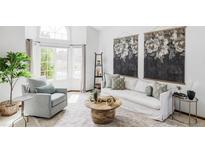 Bright living room featuring a plush sofa, accent chair, and stylish decor at 9257 Shadowglen Ct, Highlands Ranch, CO 80126