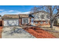 Ranch-style home with brick and siding exterior, attached garage, and landscaped yard at 1912 S Truckee St, Aurora, CO 80013