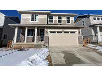 Two-story house with beige siding, attached garage, and snowy front yard at 24665 E 41St Ave, Aurora, CO 80019