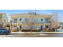 Attractive two-story townhome with light yellow exterior and landscaping at 9489 Ashbury Cir # 202, Parker, CO 80134