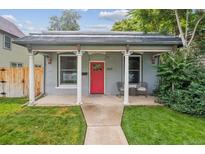 Charming home with red door, covered porch, decorative pillars, and well-maintained lawn at 3429 N Adams St, Denver, CO 80205
