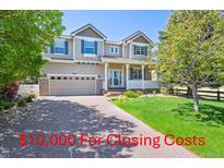 Inviting two-story home features a charming front porch, attached garage, and well-manicured lawn at 3480 Spruce Dell Ct, Castle Rock, CO 80109