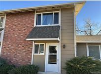 Brick front exterior of a bi-level home with a white door at 2218 Coronado N Pkwy # B, Denver, CO 80229