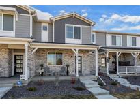 Charming townhome showcasing a stone facade, covered porch, and manicured landscaping, exuding curb appeal and inviting charm at 12205 Race St, Northglenn, CO 80241