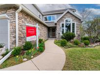 Charming stone front exterior with landscaped walkway and Steller Group real estate sign at 8312 S Peninsula Dr, Littleton, CO 80120