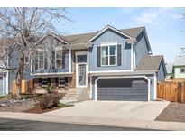 Charming two-story home with a gray garage door, brick accents, and a well-manicured front yard at 11225 W 102Nd Pl, Westminster, CO 80021