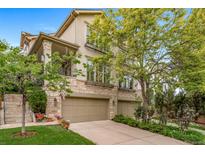 Inviting home with a stone-clad facade, a well-manicured lawn, and a spacious two-car garage at 581 Garfield St, Denver, CO 80206