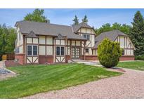 Stunning exterior showcasing Tudor style, large yard, and brick accents at 4855 S Joplin St, Aurora, CO 80015