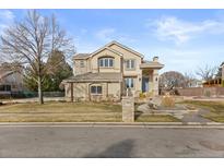 Inviting two-story home featuring a beautifully landscaped front yard with a charming water feature at 5773 S Benton Way, Littleton, CO 80123