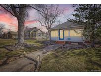 Charming single-story home with a blue door, landscaped front yard, and inviting walkway at dusk at 5668 S Foresthill St, Littleton, CO 80120