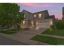 Charming two-story home with brick accents, a well-manicured lawn, and a two-car garage under a beautiful sunset at 1160 S Fultondale Ct, Aurora, CO 80018