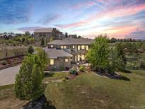 Inviting two-story home with stone accents, professional landscaping and an expansive lawn at sunset at 6995 S Ensenada St, Aurora, CO 80016