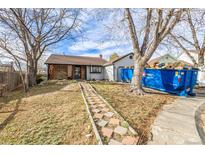 Charming home featuring a unique brick walkway leading to the front porch and a blue dumpster in the driveway at 4493 Elkhart St, Denver, CO 80239
