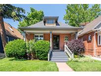 Charming brick home with covered front porch, landscaped lawn, and inviting curb appeal at 669 S Washington St, Denver, CO 80209