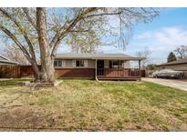 Charming single story home featuring a well maintained front yard, brick accents, and covered porch at 6895 W Oregon Dr, Lakewood, CO 80232