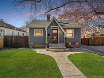 Charming gray home with a well-manicured lawn and inviting walkway, capturing a cozy and welcoming atmosphere at 3709 Ames St, Wheat Ridge, CO 80212