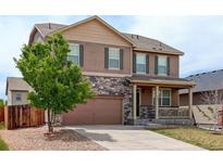 Two-story home with stone accents, shutters, covered porch and attached two car garage at 467 S 36Th Ave, Brighton, CO 80601