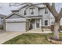 Charming two-story home with stone accents, attached garage, and well-manicured front lawn at 11746 Elizabeth Cir, Thornton, CO 80233