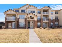 Well-maintained condominium featuring brick accents, multiple balconies, and a welcoming walkway at 5735 N Genoa Way # 11-205, Aurora, CO 80019