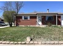 Charming brick single story home with green lawn and mature tree on a sunny day at 11923 Claude Way, Northglenn, CO 80233