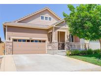 Inviting two-story home featuring a two-car garage, charming porch, and well-maintained lawn at 12513 Grape St, Thornton, CO 80241