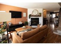 Inviting living room featuring a brick fireplace, hardwood floors, and stylish decor at 19738 Applewood Ct, Parker, CO 80138
