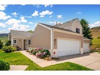Charming home with a two-car garage, manicured lawn, and vibrant flowerbeds at 535 High Point Dr, Golden, CO 80403