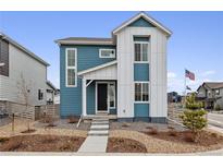 Charming two-story home features blue and white siding, landscaped front yard, and inviting entryway at 8733 Arriba Dr, Littleton, CO 80125