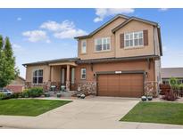 Beautiful two-story home with a stone facade and a well-maintained lawn at 436 Sage Grouse Cir, Castle Rock, CO 80109