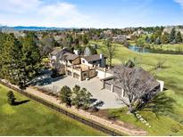Expansive estate with lush lawn, pond, multiple garages, and views of the mountains in the background at 50 Meade Ln, Cherry Hills Village, CO 80113