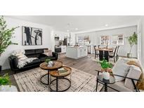Bright living room open to the kitchen with modern furniture, wood floors, and abundant natural light at 1858 S Lincoln St, Denver, CO 80210