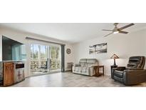 Cozy living room features a ceiling fan, balcony access, and a comfortable seating arrangement at 795 S Alton Way # 4C, Denver, CO 80247