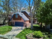 Charming two-story home featuring a brick facade, wood siding, landscaped yard, and a private driveway at 2504 S Garfield St, Denver, CO 80210