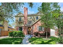 Charming two-story home featuring brick and siding, complemented by lush landscaping and a welcoming walkway at 1109 Jersey St, Denver, CO 80220