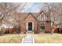 Charming two-story brick home with a landscaped front yard and beautiful trees at 3010 Cherry St, Denver, CO 80207