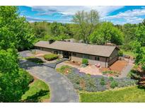 Ranch style home with gorgeous landscaping, trees, and driveway at 4701 Homestead St, Bow Mar, CO 80123