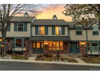 Charming townhome with brick facade and inviting covered porch beneath a beautiful sunset sky at 7068 E Briarwood Dr, Centennial, CO 80112