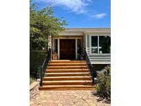 Inviting front entrance featuring a wooden door and a series of wooden steps at 6943 Fox Cir, Larkspur, CO 80118